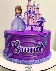 a purple birthday cake with a princess figure on top