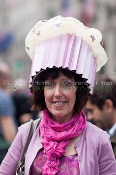 a woman with a pink hat and scarf on her head is standing in the street