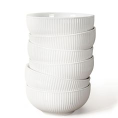 four white bowls stacked on top of each other in front of a white background,