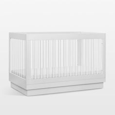 a white crib with no sheets on it, against a white wall and floor