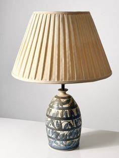 a blue and white vase with a lamp on it