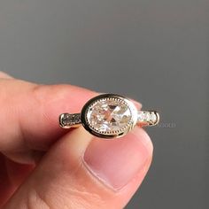 a person holding a ring with a diamond in it's center and two diamonds on the side