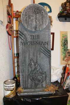 the wolfman tombstone is surrounded by other items and decorating it's surroundings