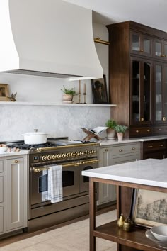 a kitchen with marble counter tops and stainless steel stove top oven, built - in cabinets