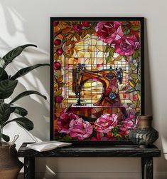 a painting on a table next to a potted plant and a sewing machine with pink flowers