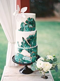 a white and green wedding cake on a table