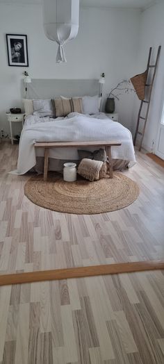 a bed sitting on top of a hard wood floor next to a wooden table and chair