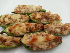 several stuffed green peppers on a white plate