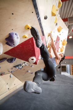 a woman climbing up the side of a rock wall