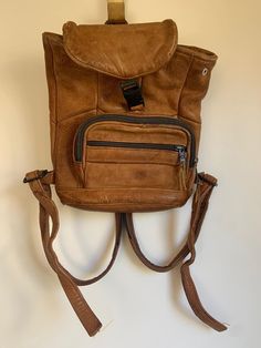 Small vintage, retro, boho brown leather backpack, rucksack, knapsack, bag 1960s or 70s, unique adjustable zipper straps. Has two pockets. Zips work great. Some minor wear and tear on the zippers (pictured). Price reflects aging.  Tag says "Genuine leather."  Pocket at the front large enough for my iPhone, but it's 7 inches across and 4 inches height, in case your smart phone is larger than mine! Vintage Brown Leather Backpack For Everyday, Vintage Satchel Backpack For Trip, Vintage Standard Backpack For Trips, Retro Brown Leather Backpack, Vintage Leather Satchel Shaped As Standard Backpack, Retro Leather Travel Backpack With Adjustable Strap, Vintage Everyday Backpack, Vintage Backpack For Trips, Retro Leather Backpack