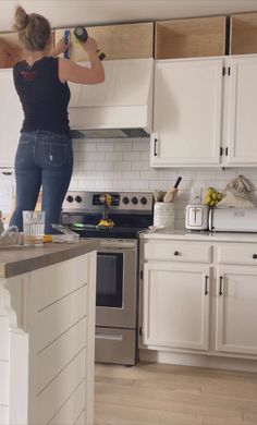 a woman standing on top of a kitchen counter