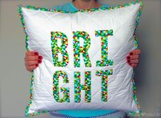 a person holding a pillow with the word art on it