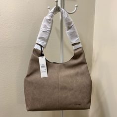 Casual Yet Trendy Hobo Shoulder Bag Perfect Size For Everyday Use Throw All Of Your Essentials Into This Fun Hobo & Get On With Your Day High Quality Vegan Leather 2 Interior Slip Pockets 1 Interior Zip Pocket Removable Pouch Magnetic Closure Approx Dims 13" H X 17" W X 3" D, 13" Handle Drop New W/Tags Better Pricing On Ig Ig: @Ari_sweirdmysteries Calvin Klein Satchel Shoulder Bag With Removable Pouch, Calvin Klein Rectangular Shoulder Bag, Everyday Rectangular Calvin Klein Shoulder Bag, Taupe Shoulder Bag With Handles, Calvin Klein Rectangular Shoulder Bag For Daily Use, Taupe Bags With Handle Drop For Shopping, Calvin Klein Leather Tote Shoulder Bag, Calvin Klein Satchel Shoulder Bag, Shopping Bag With Handle Drop In Taupe