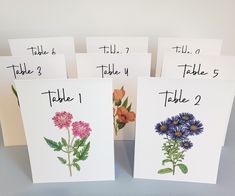 four cards with different flowers on them and the numbers 1 - 5 written in black ink