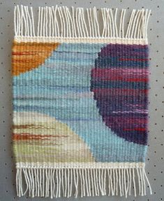 a multicolored rug with fringes on the bottom and one side that has an oval