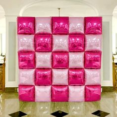 a wall made out of pink plastic bags in a room with black and white tile flooring