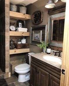 a bathroom with wooden shelving and a white toilet in the corner next to a sink