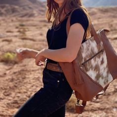 Designed for urban and western cowgirls alike, functionality and beauty collide in the Indy Carryall. We created this tote to move with you through all phases of cowgirlhood, from the baby-makin' years to work life, traveling, and beyond. Featuring structured leather and the best handpicked cowhides, this carryall has the versatility to be worn as a backpack or a tote. The roomy interior lets you keep bottles (or beer!) cold or warm, with enough pockets to fit all your essentials. Outside, you’l Country Style Brown Bag For Everyday Use, Western Saddle Bag For Everyday Use, Western Style Saddle Bags For Everyday Use, Western Leather Shoulder Bag For Everyday Use, Western Style Leather Shoulder Bag For Everyday Use, Western Style Travel Bag With Leather Backing, Western Style Rectangular Travel Bag, Western Brown Bags For Fall, Western Style Rectangular Shoulder Bag For Travel