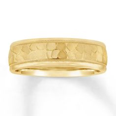 a yellow gold wedding band with an engraved design