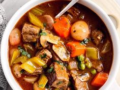 a white bowl filled with stew and vegetables