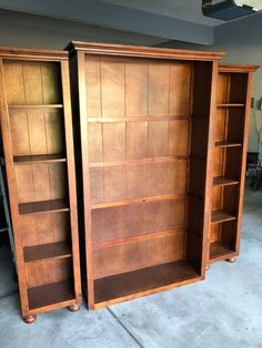 two wooden bookshelves sitting next to each other in a room with concrete floors