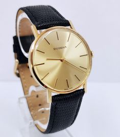 A fairly rare men's (unisex) 14k solid gold Swiss DUGENA watch with the classic Bauhaus look, with a gold punch on caseback, manual winding watch with a gold color dial, gorgeous, completely original, with lizard calf leather strap. The reverse is engraved, the watch is in good working condition, almost unworn pristine condition considering age, no scratches on the glass and case. Dates: 1979 Case size: 34 mm Total weight: approx. 29g A true classic, worth collecting! PLEASE NOTE: ALL MY WATCHES Antique Yellow Gold Watches For Business, Antique Gold Watch For Business, Business Watches In Yellow Gold With Gold Clasp, Gold Punch, Wrist Watches, Slovenia, Gold Watch, Leather Watch, Calf Leather