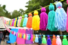 many colorful tassels hanging from a line