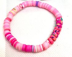 Add a pop of color and a touch of charm to your wrist with this handmade polymer clay beaded bracelet. This lovely piece features a perfect blend of pink and purple spacer beads, creating a delightful contrast that will add a playful and feminine flair to any outfit. Whether you're looking for a unique accessory for yourself or a thoughtful gift for a friend, this friendship bracelet is sure to bring joy and sweet style to your day. Made with care and attention to detail, each bead is uniquely crafted to ensure a one-of-a-kind piece that you'll love to wear on repeat. Bohemian Adjustable Polymer Clay Bracelets, Playful Pink Heishi Beads Stretch Bracelet, Colorful Beaded Polymer Clay Friendship Bracelets, Friendship Beaded Polymer Clay Stretch Bracelet, Playful Handmade Polymer Clay Bracelets, Playful Pink Heishi Beads Bracelets, Pink Wooden Bead Bracelet Jewelry, Pink Wooden Beads Bracelet Jewelry, Pink Beaded Bracelets With Wooden Beads As Gifts