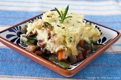 mashed potatoes, green beans and carrots in a dish on a tablecloth