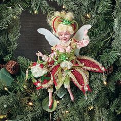 a christmas ornament with a fairy on it's back hanging from a tree