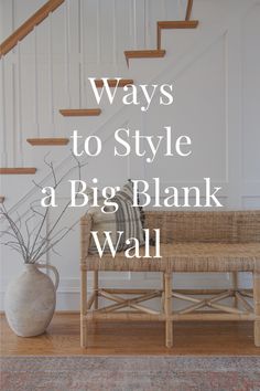 a bench sitting in front of a stair case next to a white wall with the words, ways to style a big blank wall