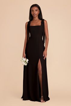 a woman wearing a black dress with a slit down the side and a flower in her hand