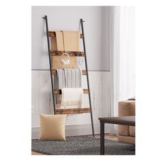 a ladder is holding towels and blankets in a living room with a rug on the floor