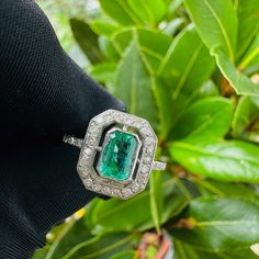 A stunning Art Deco style, Emerald and diamond ring, featuring an Emerald, mounted in a collet setting, surrounded with a row of twenty-two, eight cut diamonds, all beautifully made in Platinum with diamond mounted shoulders terminating to a slender shank. The Emerald is a beautiful green coloured gemstone, it is an emerald-cut and measures 6.5 x 4.7mm with an estimated carat weight of 0.65cts The diamonds are eight-cuts, they are bright and clean with an estimated combined carat weight of 0.28c Art Deco Oval Emerald Ring With Brilliant Cut, Art Deco Diamond Ring With Gemstone, Octagon Emerald Ring With Diamond Accents, Luxury Octagon Halo Setting Ring, Classic Octagon Emerald Ring With Diamond Accents, Classic Emerald Ring With Diamond Accents And Octagon Shape, Art Deco Emerald Ring With Diamond, Gia Certified Oval Emerald Ring In Art Deco Style, Gia Certified Emerald Cut Art Deco Rings