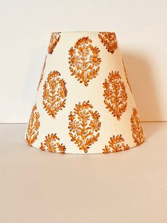 an orange and white lamp shade sitting on top of a table