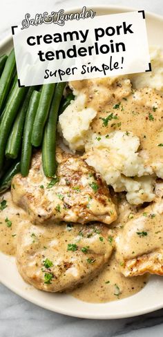 a white plate topped with chicken, mashed potatoes and green beans covered in gravy