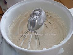 a whisk in a white bowl on top of a table