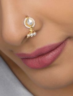 a woman wearing a nose ring with pearls on the end and a pearl bead in the middle