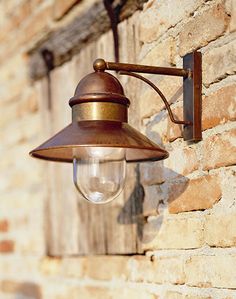 an old fashioned wall light on the side of a brick building with no one in it