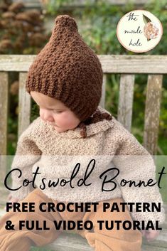 a baby sitting on a bench wearing a knitted hat and mittens with text overlay that reads, cotswold bonnet free crochet pattern & full video tutor