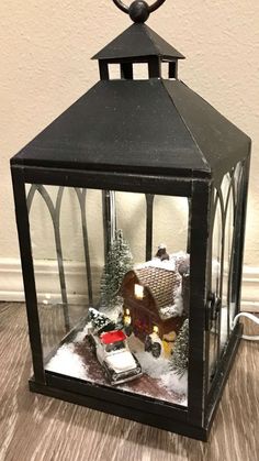 a christmas scene in a glass lantern on the floor