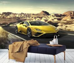 a yellow sports car is driving down the road with mountains in the background wall mural