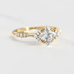 a gold ring with a princess cut diamond