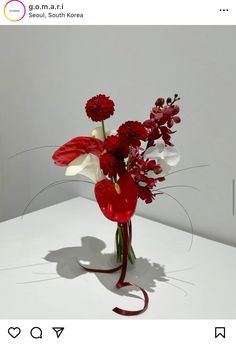 a vase filled with red and white flowers