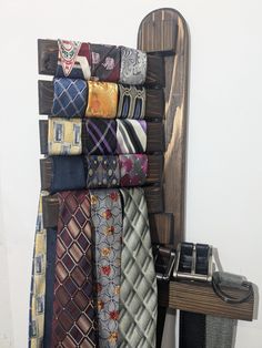 there are many different ties hanging up on the wall next to a desk and chair