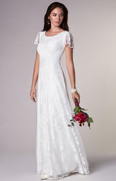 a woman in a long white dress holding a bouquet