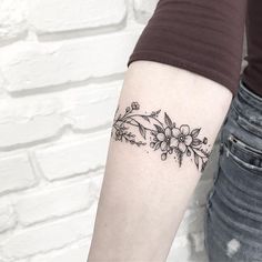 a woman's arm with a flower tattoo on the left side of her arm