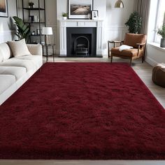 a living room with a large red rug on the floor and a fire place in the corner