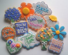 decorated cookies with thank you messages and flowers are on a white table top, ready to be eaten