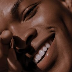 a woman smiling and holding her hand to her face